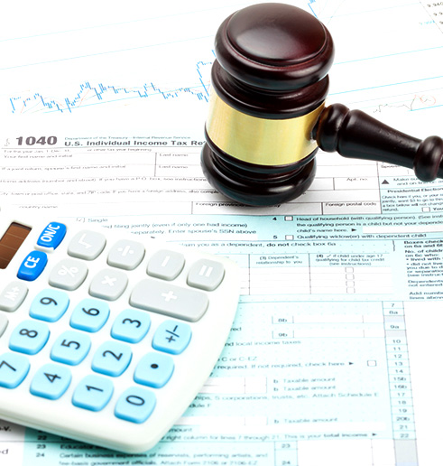 A gavel resting on a calculator and tax papers